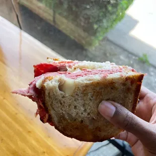 a person holding a half eaten sandwich