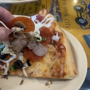 This is me holding the Manhattan topping on a pepperoni pizza.