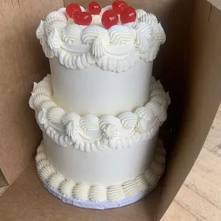 a cake in a box with cherries on top