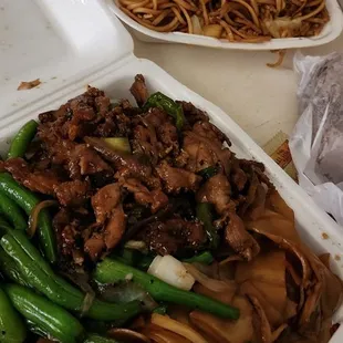 two takeout containers of chinese food