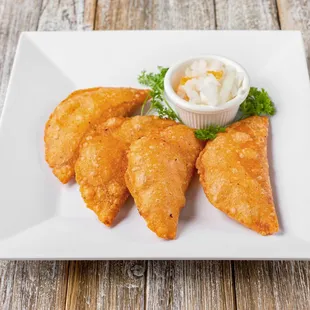 three fried pastries on a white plate