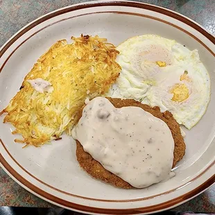 a plate of food with eggs, hash browns and gravy