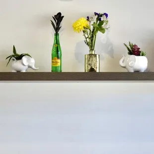 a shelf with vases and flowers