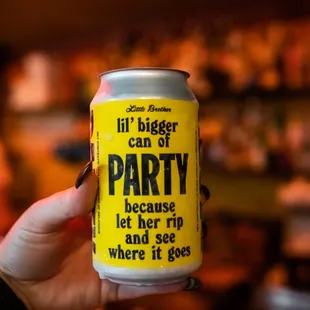 a person holding a can of party beer