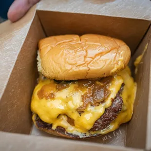 a cheeseburger in a cardboard box