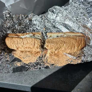 two sandwiches wrapped in tin foil