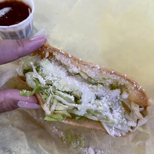 a hand holding a sandwich