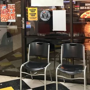 two chairs in front of a pizza parlor