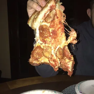 Dripping with grease, and instantly breaking due to the pizza being completely "raw" and not nearly cooked long enough.