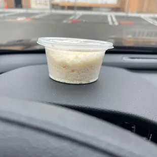 a small plastic container on the dashboard of a car