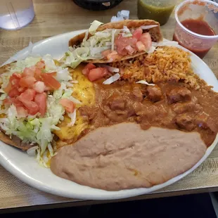 #16 Combination: ground beef taco, bean tostada, cheese &amp; onion enchilada, chunky beef or pork, rice, beans, &amp; choice of tortillas.