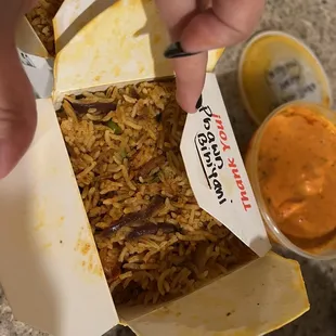 a hand grabbing a piece of food from a box