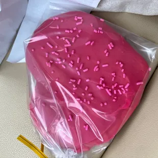 a pink heart shaped cake with sprinkles