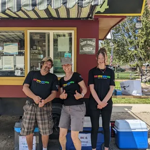 three people standing in front of a food truck