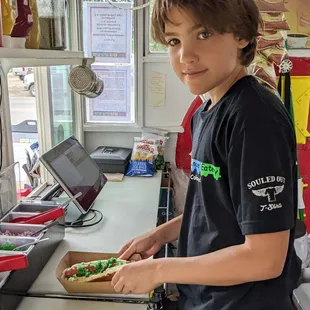 a young boy making a sandwich