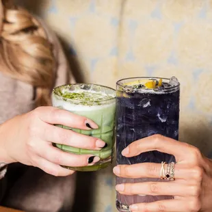 Two people clinking cocktail glasses