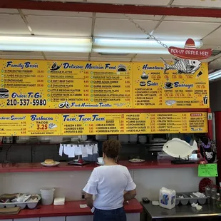 a woman standing in front of the menu