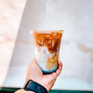 a hand holding a cup of coffee
