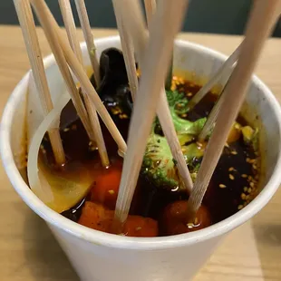 a bowl of soup with chopsticks