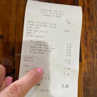 a person's hand holding a receipt