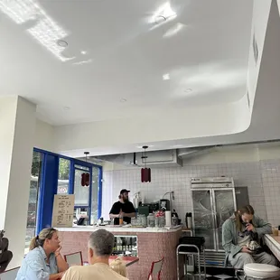 people sitting at tables in a diner