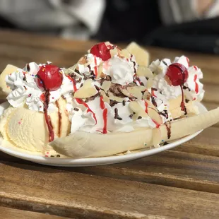a banana split topped with whipped cream and cherries