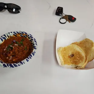 a bowl of chili and a plate of bread