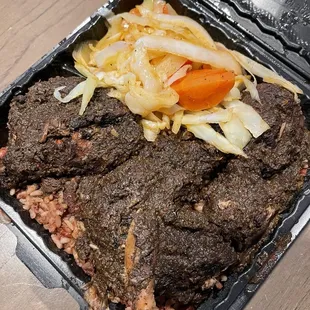 Jerk chicken entree with rice &amp; peas and cabbage.