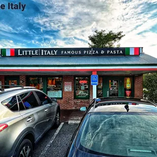 cars parked in front of a little italy restaurant