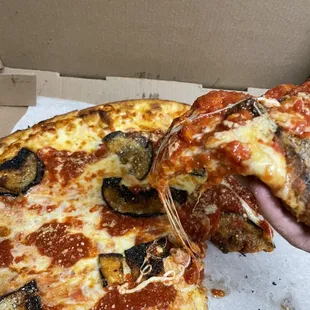 a hand holding a slice of pizza