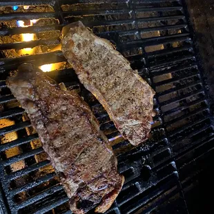 two steaks on a grill