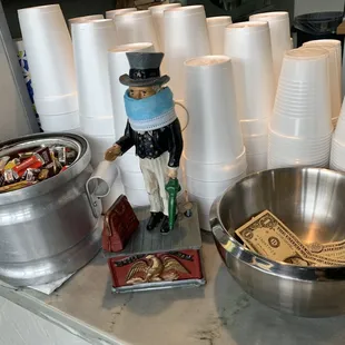 a man in a top hat with money in a bowl