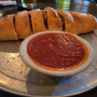 a plate of bread and a bowl of tomato sauce