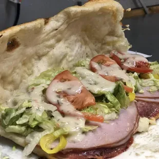 a sub sandwich with lettuce, tomato, and ham