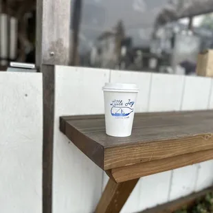 a cup of coffee on a bench