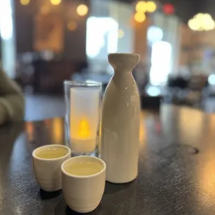 a pitcher and cups on a table