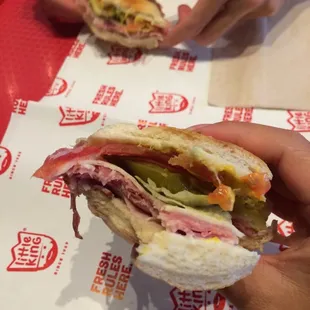 a person holding a sandwich in their hand