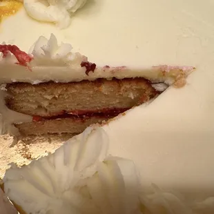 See the excessively thick frosting, which had a chemical taste, covering the dry awful cake. Note the bright red fake fruit filling.