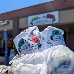 two bags of sandwiches in front of a store