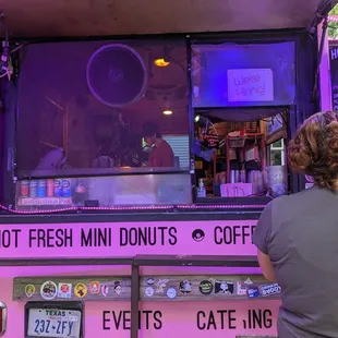 a woman standing in front of a food truck