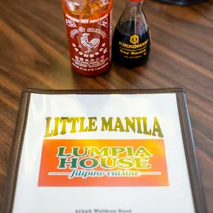 a menu and a bottle of sauce