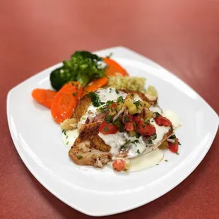 Blackened tilapia with sautéed vegetables, cilantro rice, pineapple pico de galló and lemon butter sauce.