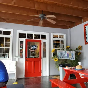 a red picnic table in front of a red door