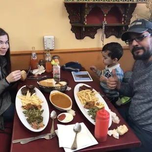 a man and woman sitting at a table with a child