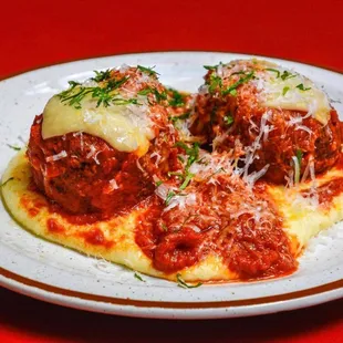 two meatballs covered in sauce and cheese