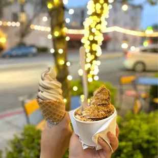 Swirl soft serve; one with cone and one with butter cake crumbles