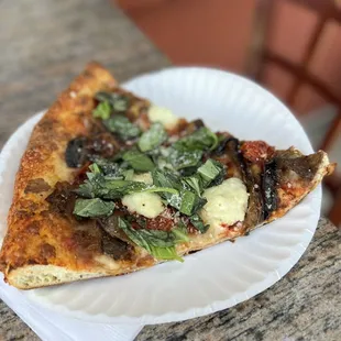 a slice of pizza on a paper plate