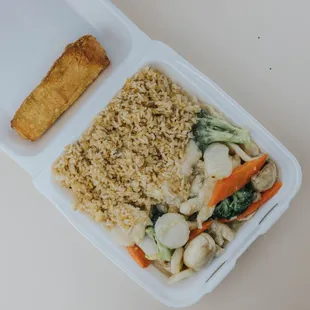 a take out container with rice and vegetables
