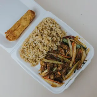 a take out container with rice and vegetables