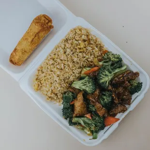 a takeout container with rice, broccoli, and tofu